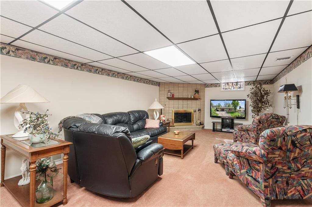 25 Willow Drive Monessen, PA 15062 - Photo 22 of 33 a living room with furniture a fireplace and a flat screen tv
