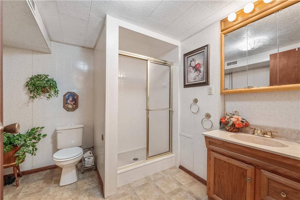 25 Willow Drive Monessen, PA 15062 - Photo 23 of 33 a bathroom with a toilet a sink and mirror
