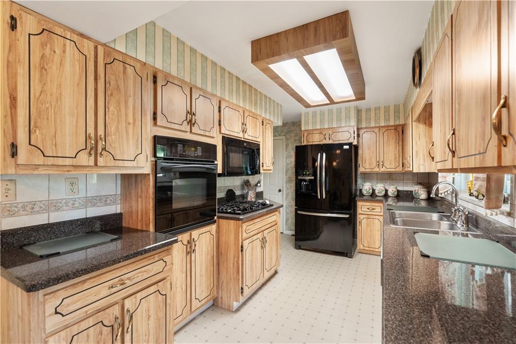 25 Willow Drive Monessen, PA 15062 - Photo 8 of 33 a kitchen with stainless steel appliances granite countertop a refrigerator a stove and a sink with cabinets