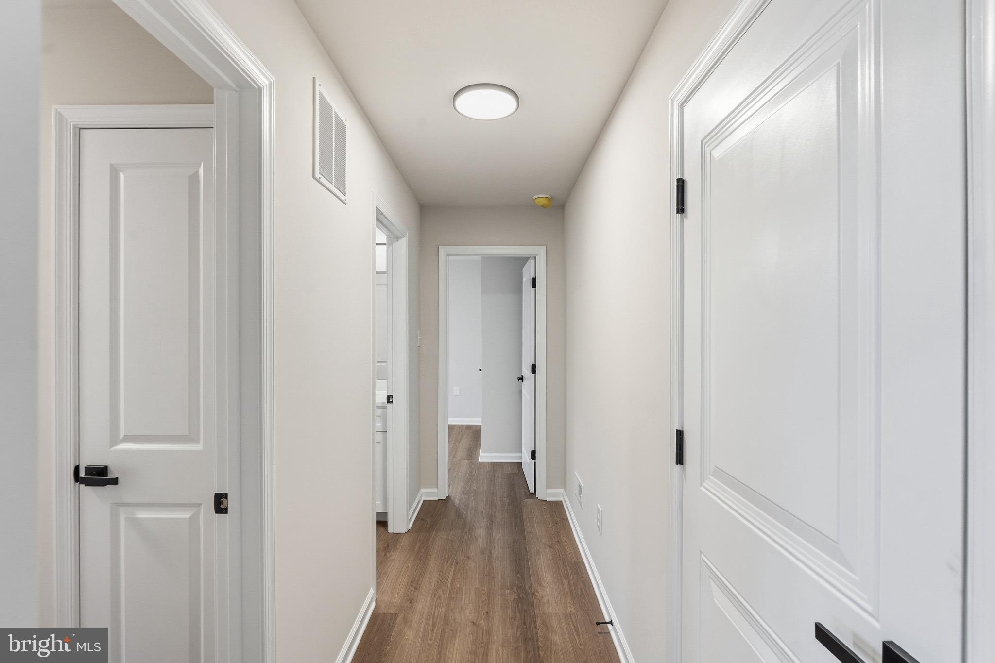 212 Lotus Avenue Voorhees, NJ 08043 - Photo 13 of 39 a view of a hallway with wooden floor and a bathroom