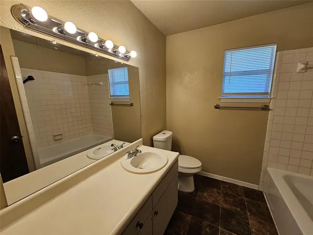 a bathroom with a sink a toilet a light fixture and a mirror