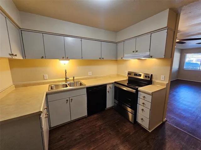 a kitchen with a sink cabinets and wooden floor
