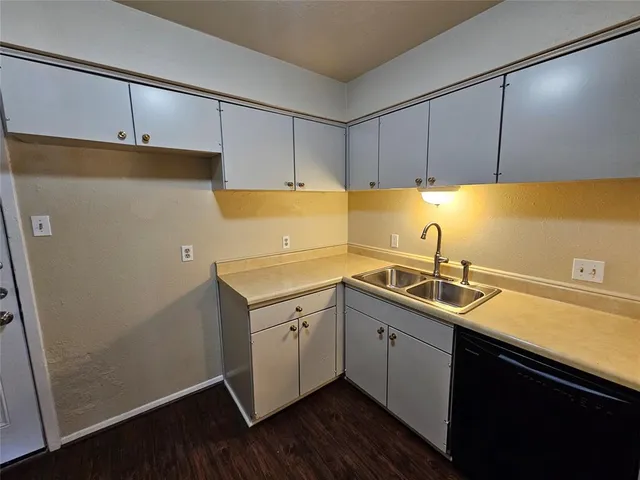 a kitchen with a sink a refrigerator and cabinets