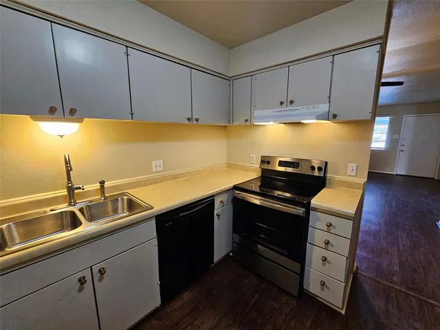 a kitchen with stainless steel appliances a sink dishwasher stove and cabinets