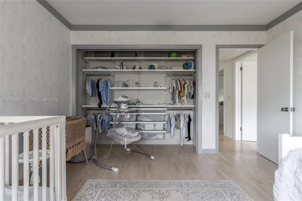 a living room with a wooden floor and a book shelf