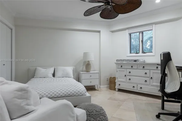 a bedroom with a bed a chandelier and a window