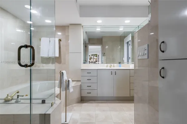 a bathroom with a mirror sink and tub