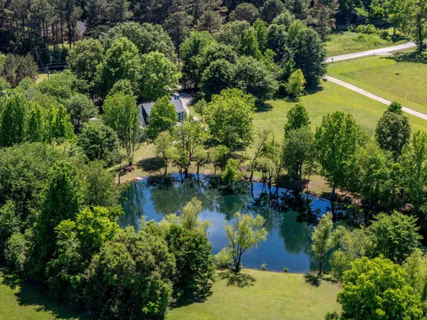 an aerial view of residential houses with outdoor space and trees all around