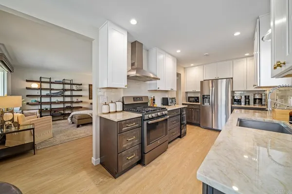 a large kitchen with stainless steel appliances lots of counter space and a sink