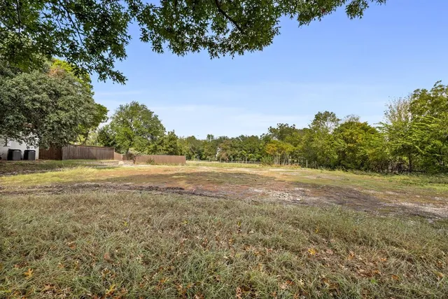 a view of a field with trees in the background