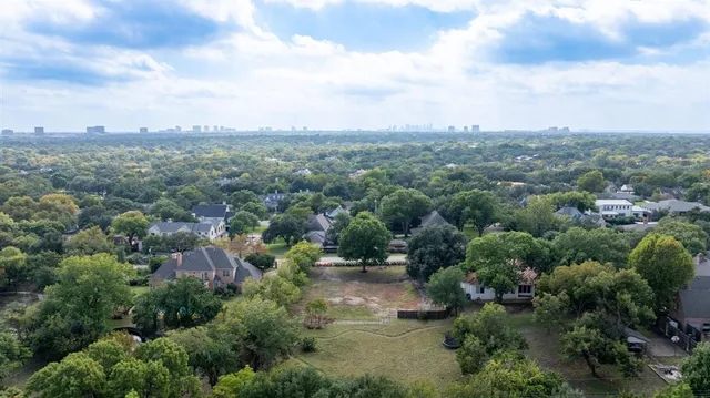 an aerial view of residential house with green space and fog