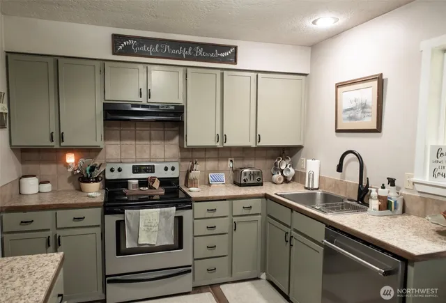 a kitchen with stainless steel appliances granite countertop a sink stove and cabinets