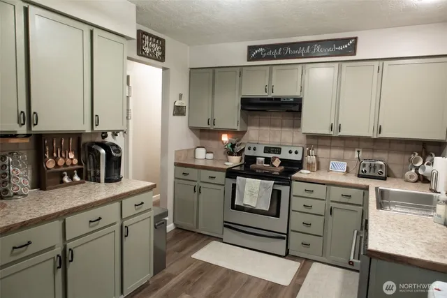 a kitchen with stainless steel appliances granite countertop a stove a sink and a refrigerator