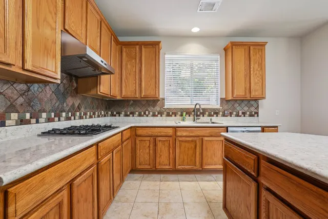 an empty room with windows and chandelier fan
