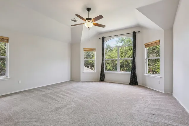 an empty room with fan and windows