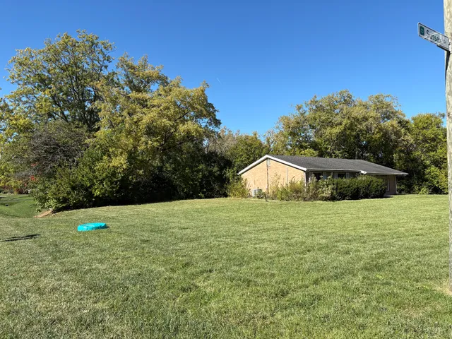 a house with green field in front of it