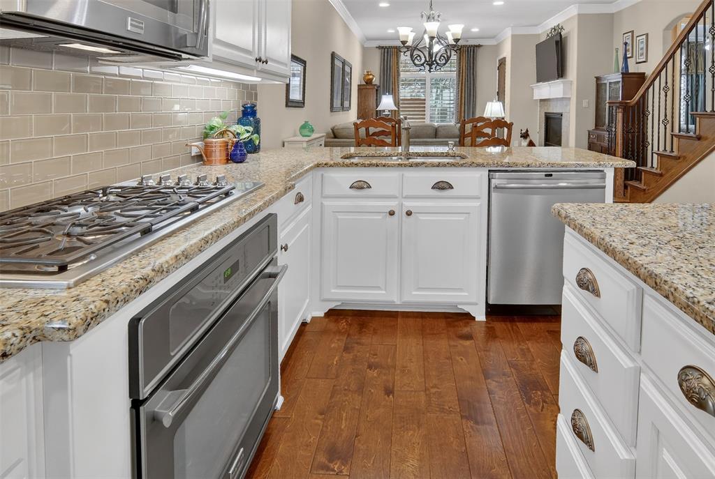 825 Milton Way Coppell, TX 75019 - Photo 13 of 35 a kitchen with kitchen island granite countertop a sink stove and cabinets