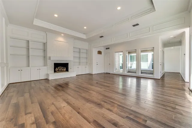 an empty room with wooden floor and fireplace