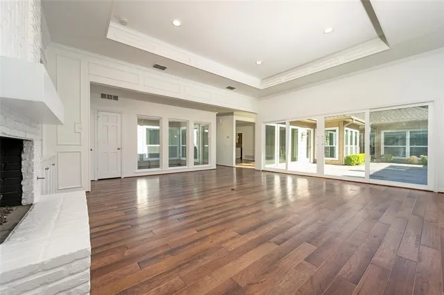 a view of empty room with wooden floor and fireplace