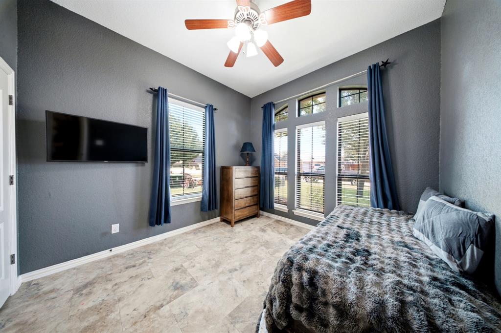 600 Aspen Street Pilot Point, TX 76258 - Photo 14 of 39 Bedroom or Office.Room with contemporary gray walls, wood-finish flooring, a ceiling fan, and multiple windows for natural light