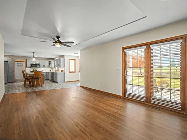 a view of a livingroom with wooden floor and a ceiling fan