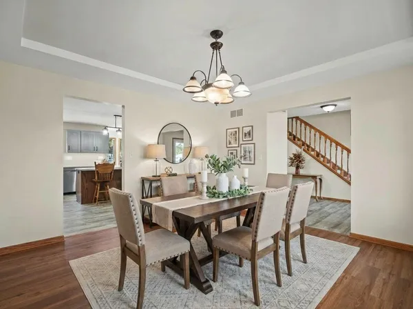 a view of a dining room with furniture a chandelier and wooden floor
