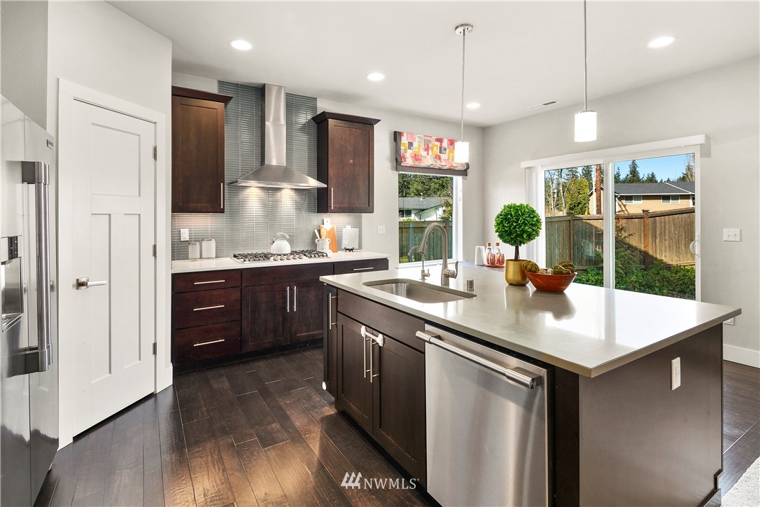 207 176th Place Southwest Bothell, WA 98012 - Photo 11 of 36 a kitchen with stainless steel appliances granite countertop a sink a stove and a wooden floors