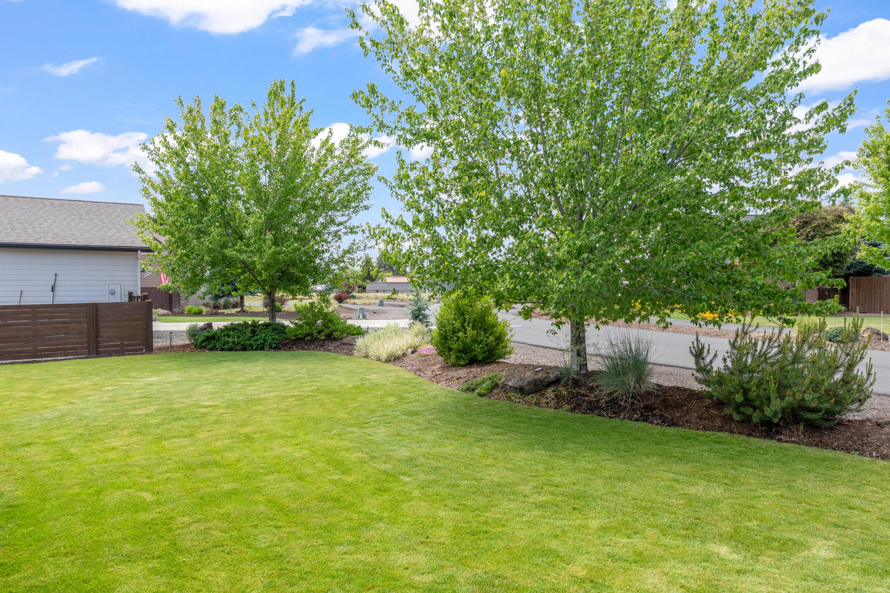 210 Northwest Saddle Ridge Loop Prineville, OR 97754 - Photo 30 of 38 a view of a big yard with plants and large trees