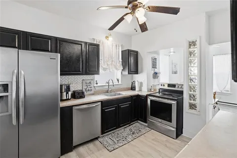 a kitchen with stainless steel appliances a stove a sink and a refrigerator