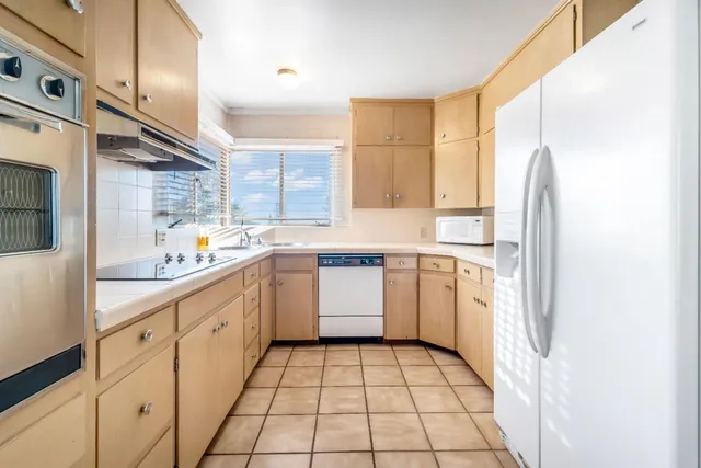 a kitchen with stainless steel appliances a refrigerator sink and cabinets