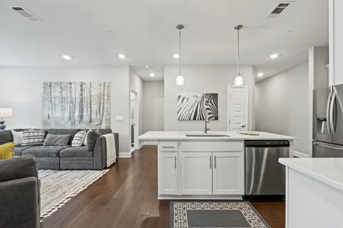 a view of a kitchen counter space wooden floor and stainless steel appliances