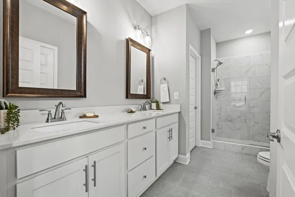 a bathroom with double vanity sinks and a mirror