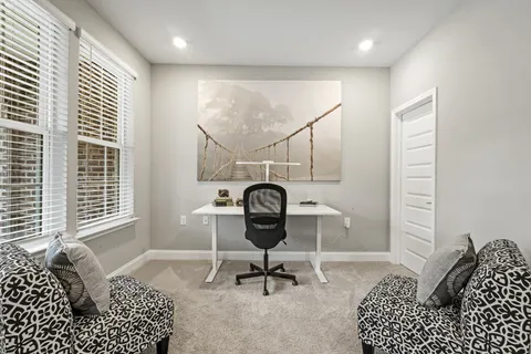 a view of a workspace with furniture and a window