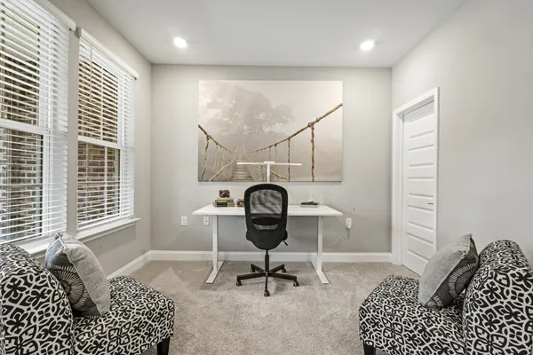 a view of a workspace with furniture and a window