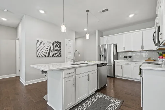 a kitchen with white cabinets and white appliances