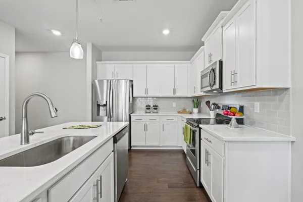 a kitchen with a sink cabinets a counter top space and stainless steel appliances