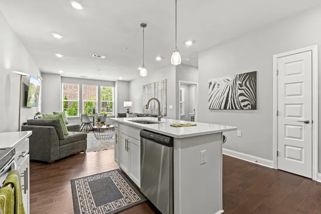 a kitchen with kitchen island granite countertop a sink cabinets and wooden floor