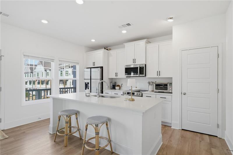 3158 Webb Road Milton, GA 30004 - Photo 11 of 36 a kitchen with stainless steel appliances kitchen island granite countertop a stove a sink a refrigerator white cabinets and wooden floor