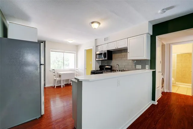 a kitchen with a refrigerator and a stove top oven
