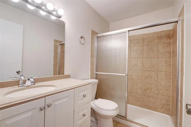 a bathroom with a granite countertop sink toilet and shower