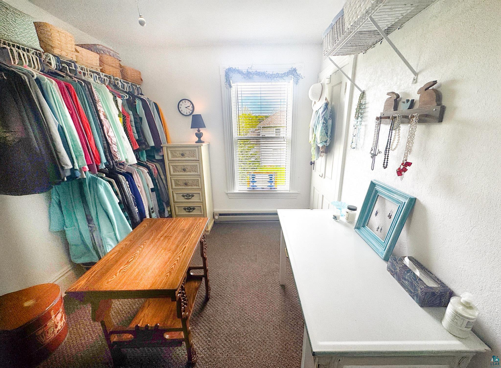 303 East 5th Street Washburn, WI 54891 - Photo 28 of 34 Walk-in closet featuring extensive built-in shelving and hanging rods, a window for natural light, and carpet flooring