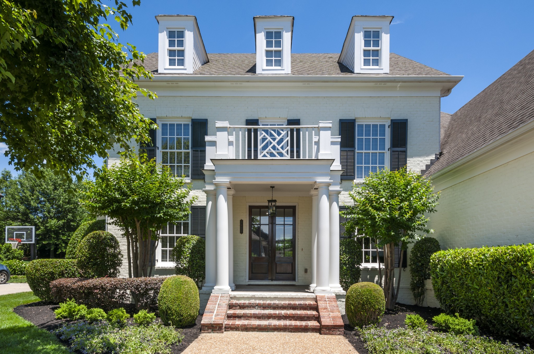 a front view of a house with a garden