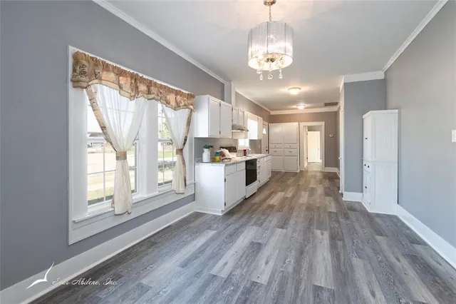 a view of a kitchen with wooden floor and stainless steel appliances