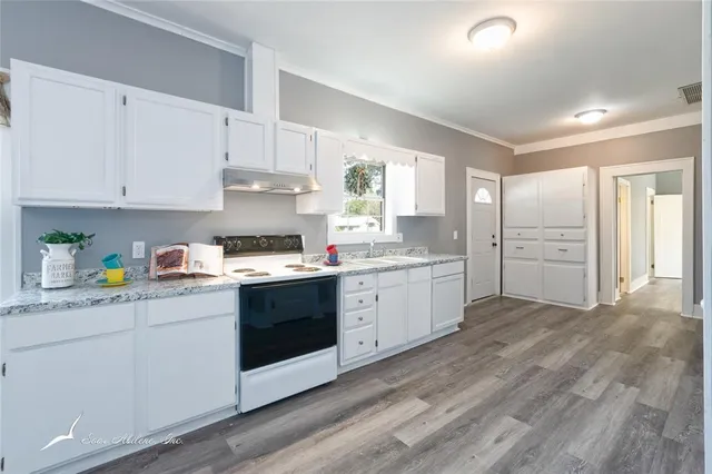 a kitchen with granite countertop white cabinets and white appliances