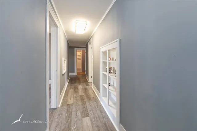 a view of a hallway with wooden floor