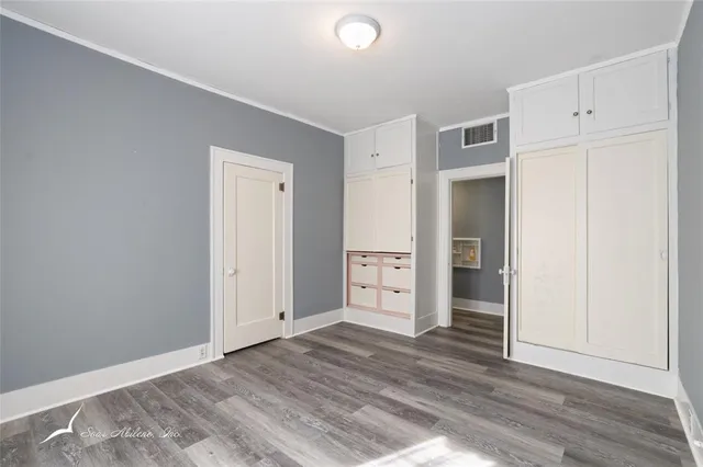 an empty room with closet and wooden floor