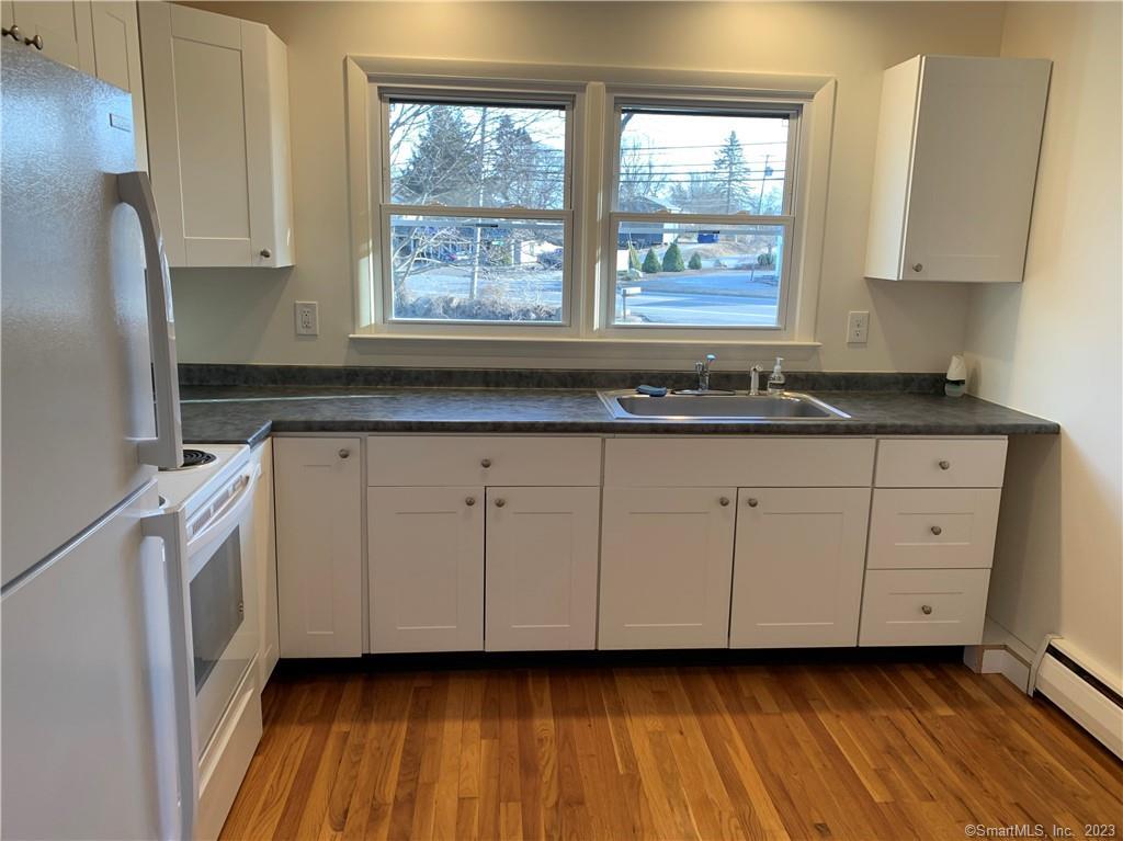 a kitchen with granite countertop white cabinets and a large window