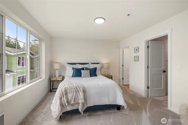 a bedroom with a bed and a large window