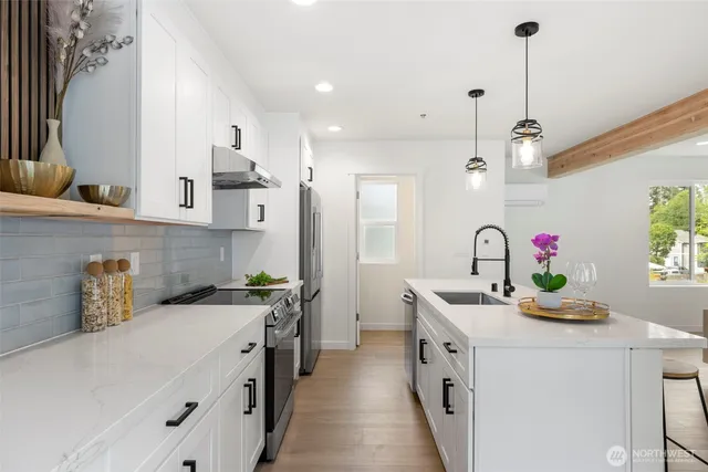 a kitchen that has a sink a stove and a table