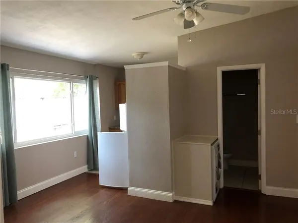 an empty room with wooden floor and a window